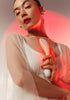 Woman holding the white LELO MONA Spectra with red LEDs